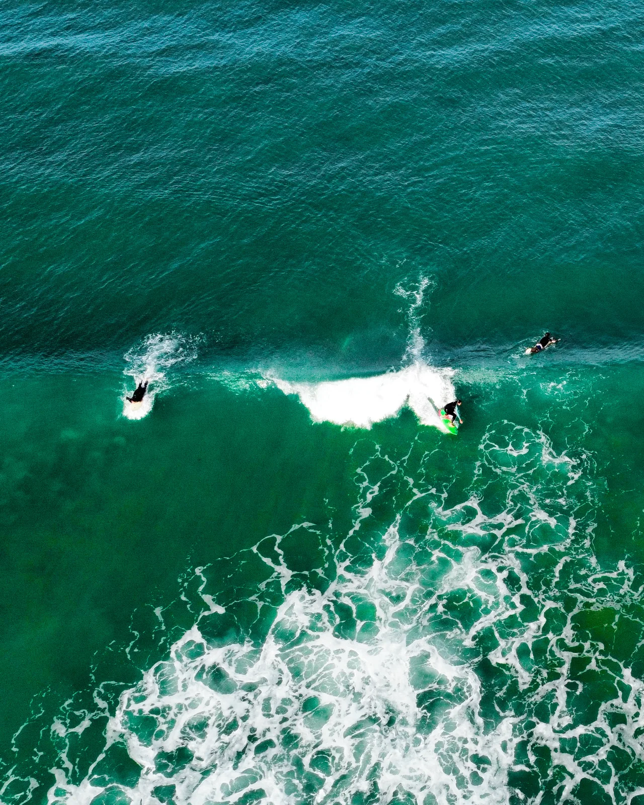 Surfistas cogiendo una ola en Roche